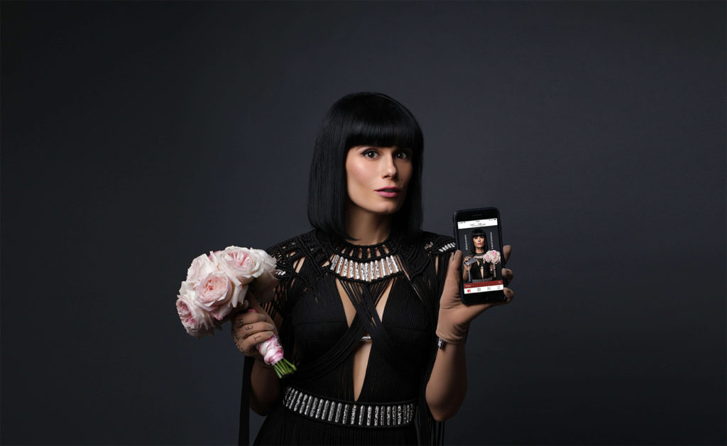 Сола Монова с телефоном Apple в руках и мобильным приложением Сола книги